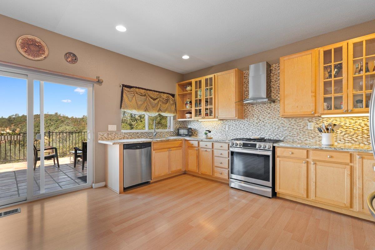 23392 Meyer Ravine Road Grass Valley, CA 95949 - Photo 4 of 58 a kitchen with a stove a sink and a refrigerator