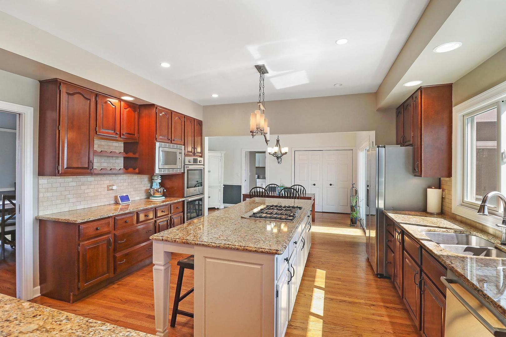 159 Helm Road Barrington Hills, IL 60010 - Photo 15 of 57 a kitchen with stainless steel appliances granite countertop a stove top oven a sink dishwasher a dining table and chairs with wooden floor