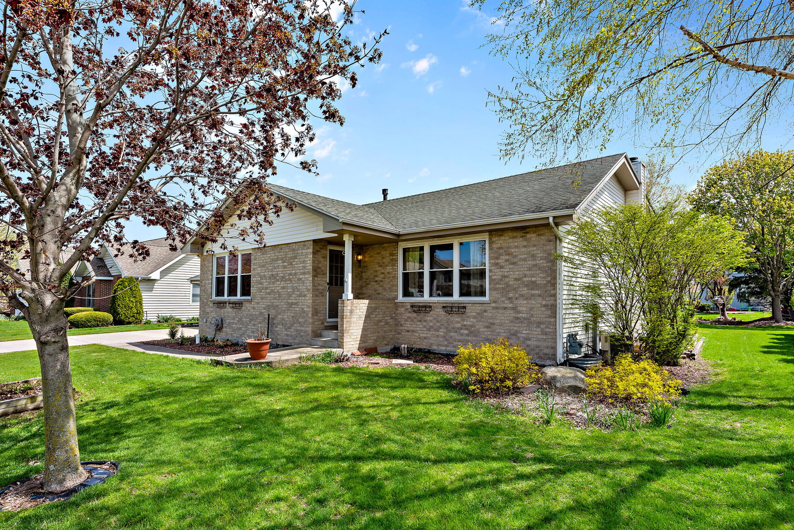 372 Jefferson Street Manteno, IL 60950 - Photo 3 of 24 a front view of a house with a garden and trees