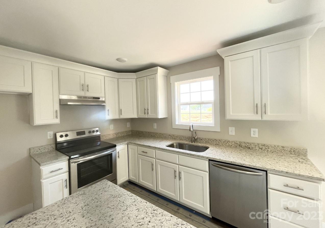 1789 Rad Drive Conover, NC 28613 - Photo 3 of 4 a kitchen with granite countertop white cabinets sink and stainless steel appliances