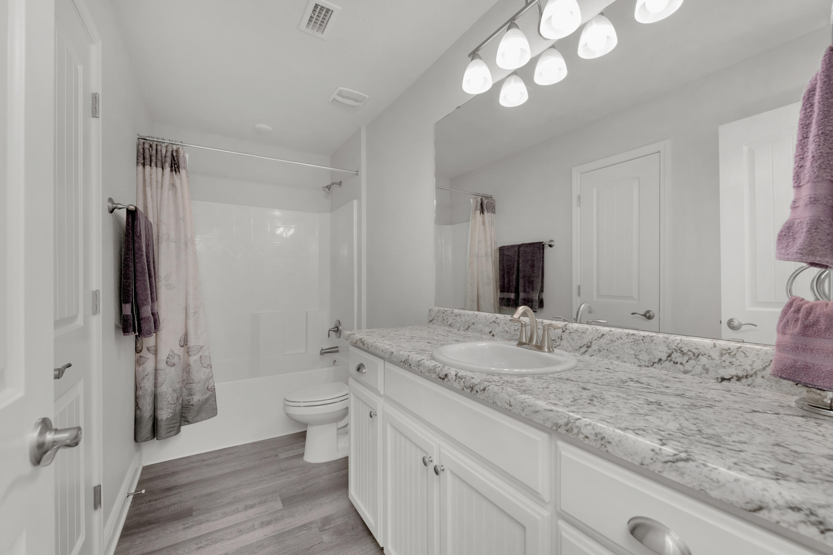 6042 Hidden Valley Road Crestview, FL 32539 - Photo 19 of 34 a bathroom with a sink a toilet and a large mirror