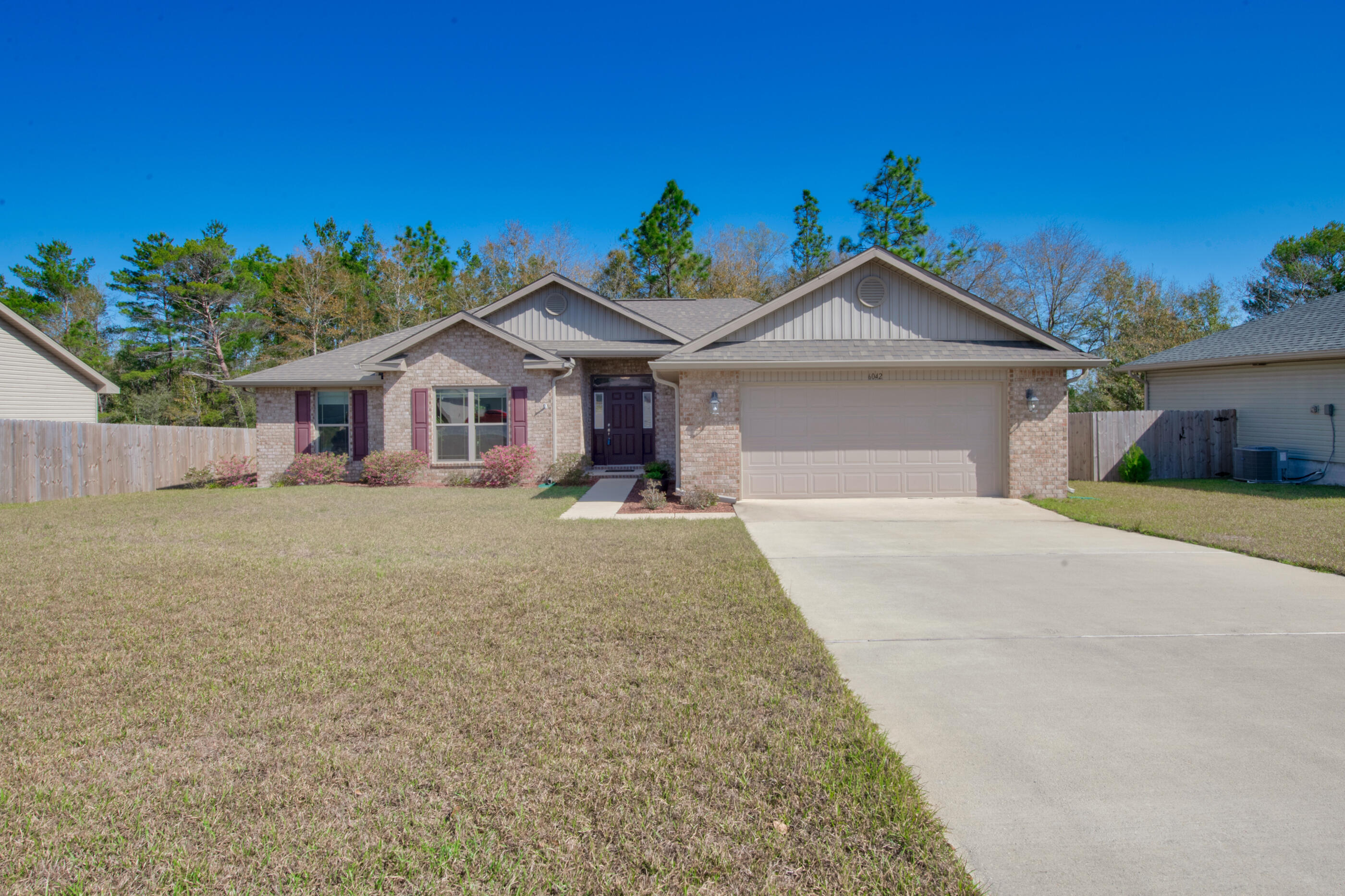 6042 Hidden Valley Road Crestview, FL 32539 - Photo 2 of 34 a front view of a house with a yard and potted plants