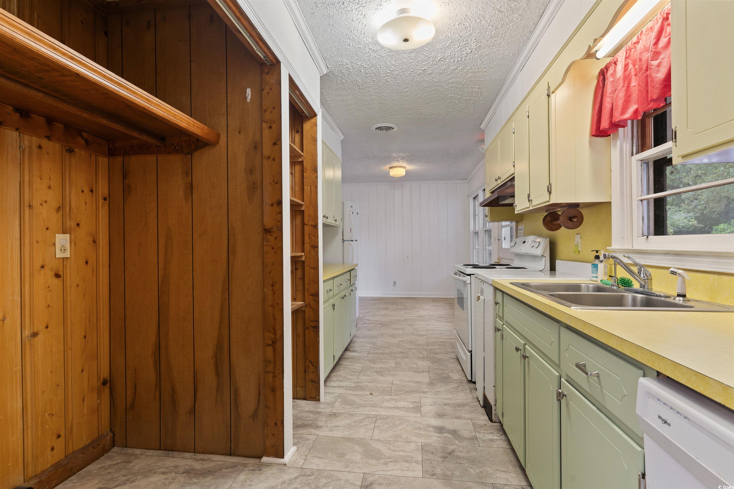 815 Bellamy Road North Myrtle Beach, SC 29582 - Photo 8 of 24 Kitchen with wooden walls, white appliances, a tex