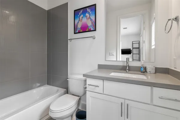a bathroom with a granite countertop toilet a sink and a bathtub