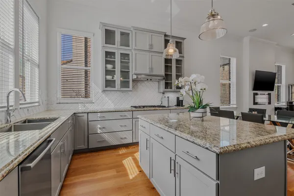 a kitchen with granite countertop stainless steel appliances a sink stove and refrigerator