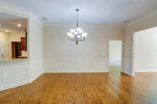 a view of a room with wooden floor and chandelier