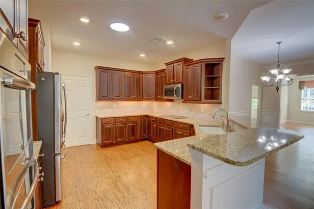 a kitchen with a sink a counter top space cabinets and stainless steel appliances