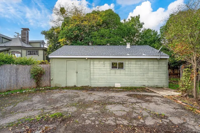 a view of a yard in front of a house with large tree