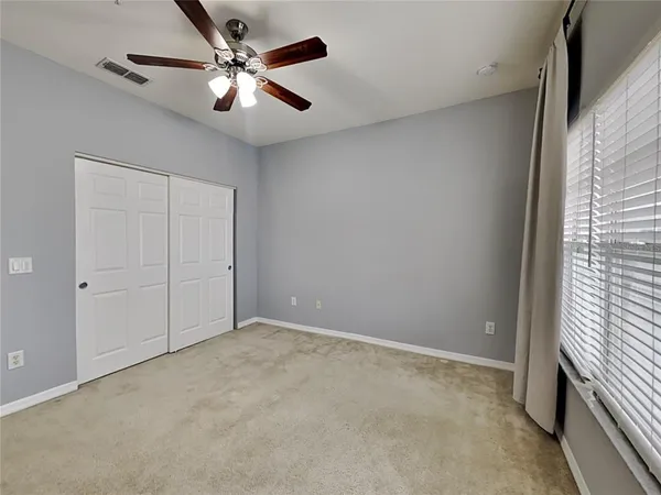a view of an empty room with a ceiling fan