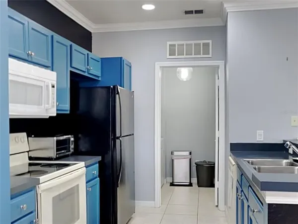 a kitchen with a refrigerator and a stove top oven