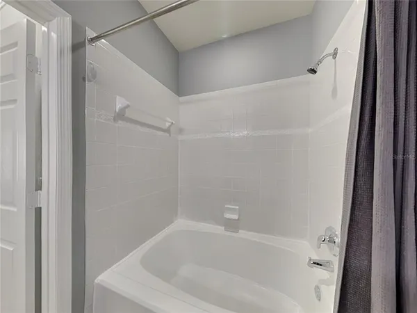 a white bath tub sitting next to a white sink and vanity