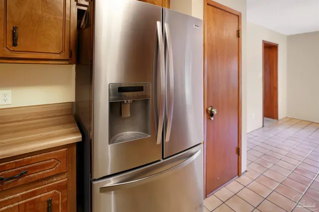 a metallic refrigerator freezer and a stove sitting inside of a kitchen