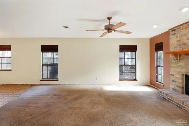 a view of an empty room with a fireplace and a window