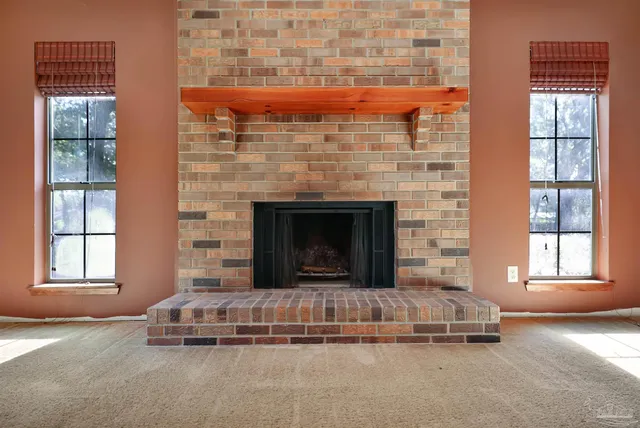 a living room with a fireplace and windows