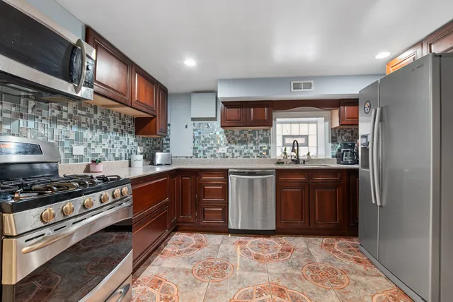 a kitchen with stainless steel appliances granite countertop a stove a sink and a refrigerator