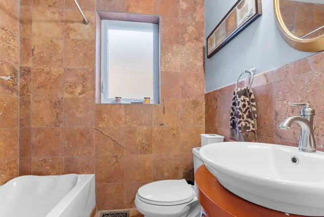 a white toilet sitting next to a bathroom sink and tub