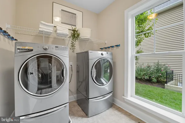 a spacious bedroom with a bed a chandelier and a potted plant