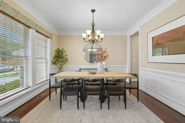 a dining room with furniture a chandelier and wooden floor