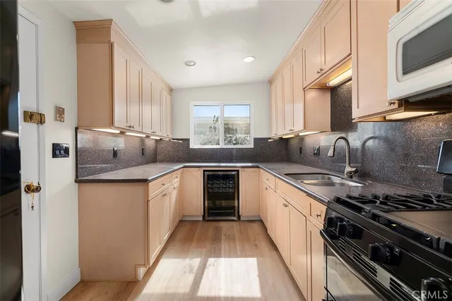 a kitchen with stainless steel appliances granite countertop a sink stove and microwave