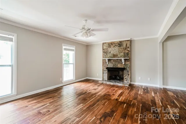 wooden floor fireplace and windows in an empty room