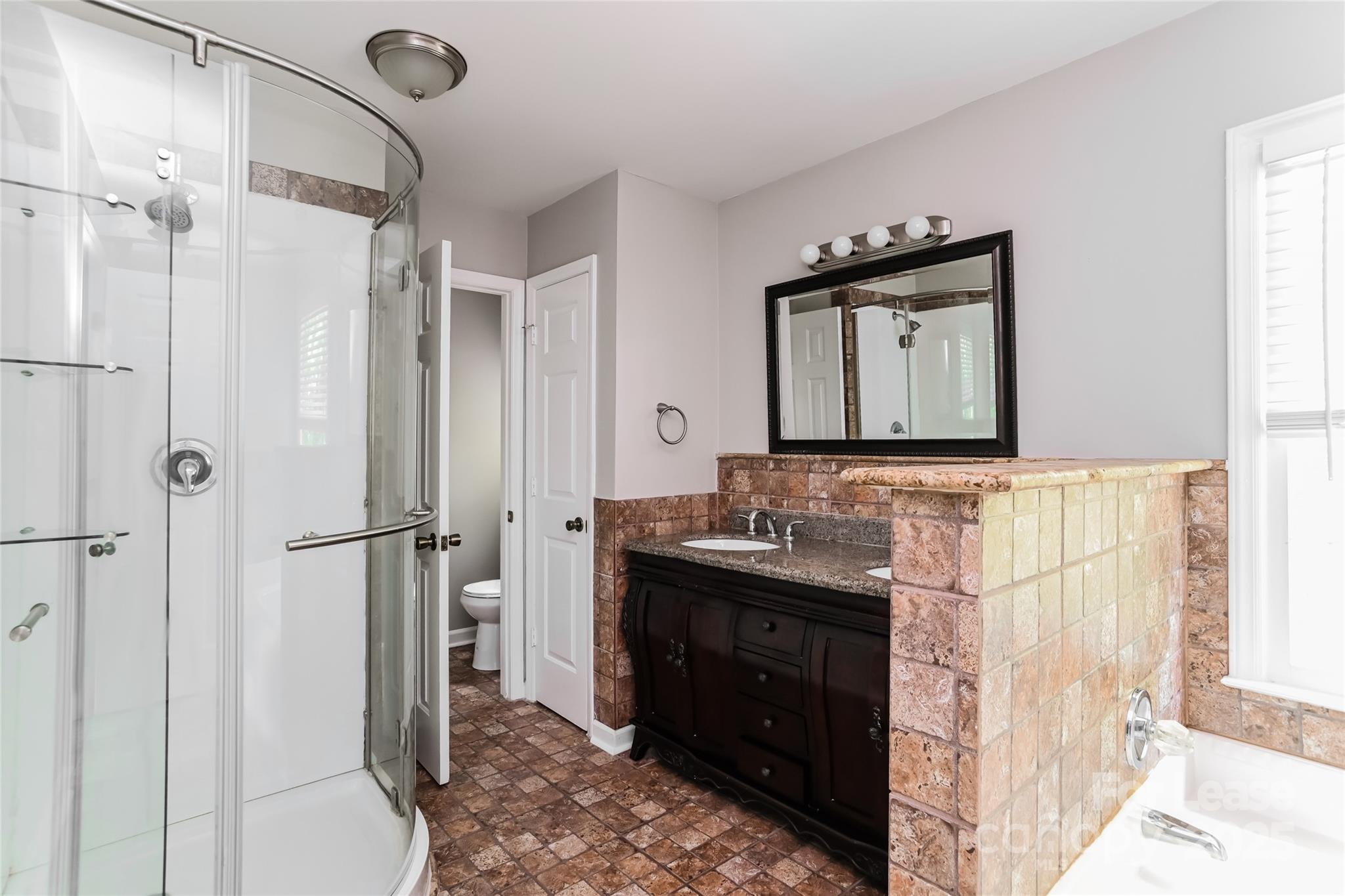2331 Hunters Bluff Drive Matthews, NC 28105 - Photo 9 of 17 a bathroom with a granite countertop sink mirror and shower