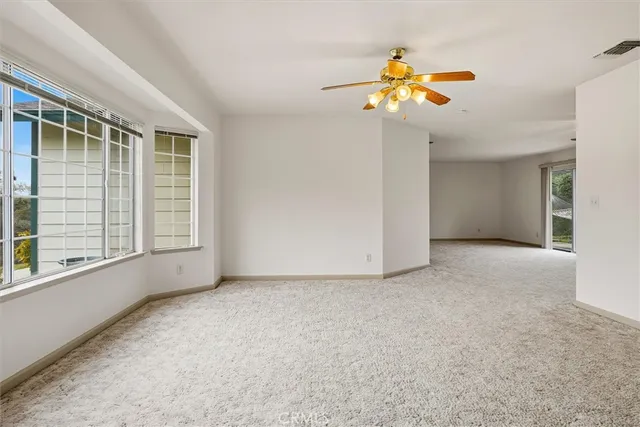 a living room with furniture a fireplace a large window and a flat screen tv