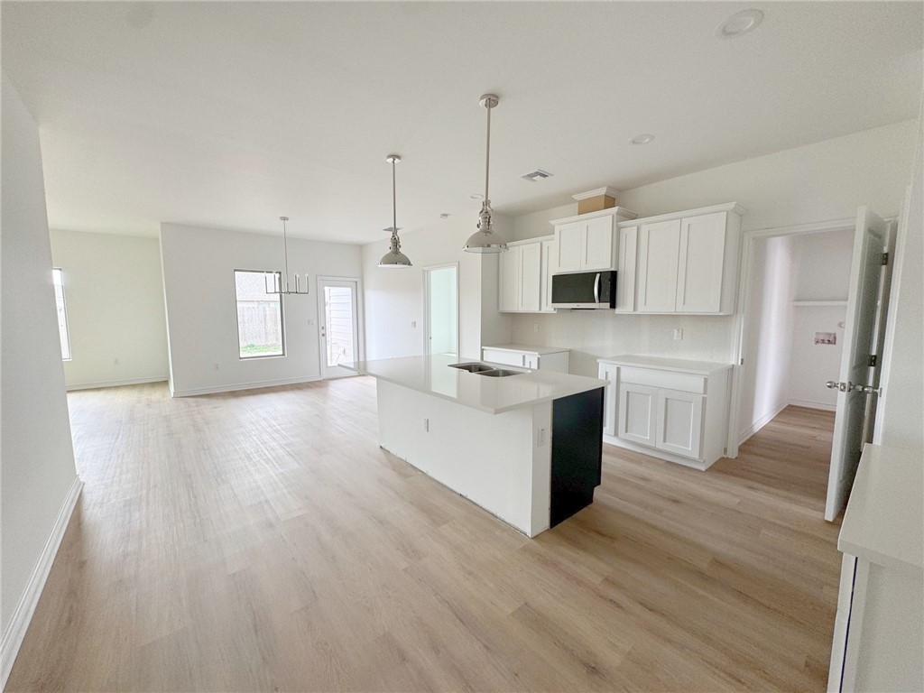 2105 Fury Portland, TX 78374 - Photo 10 of 23 a large kitchen with cabinets wooden floor and stainless steel appliances