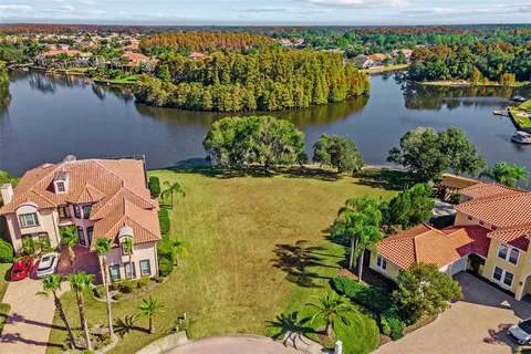 an aerial view of residential houses with outdoor space and a lake view