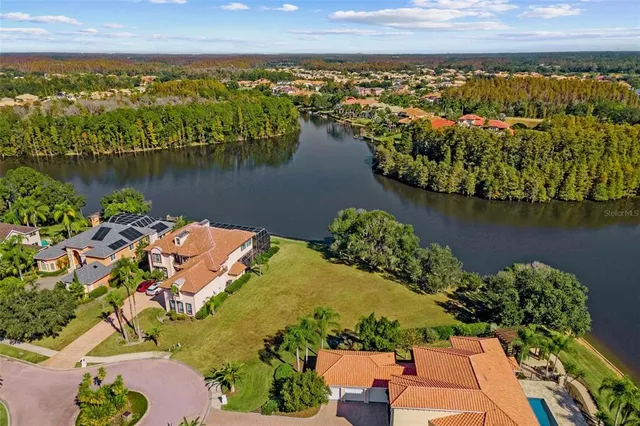 an aerial view of residential houses with outdoor space and lake view