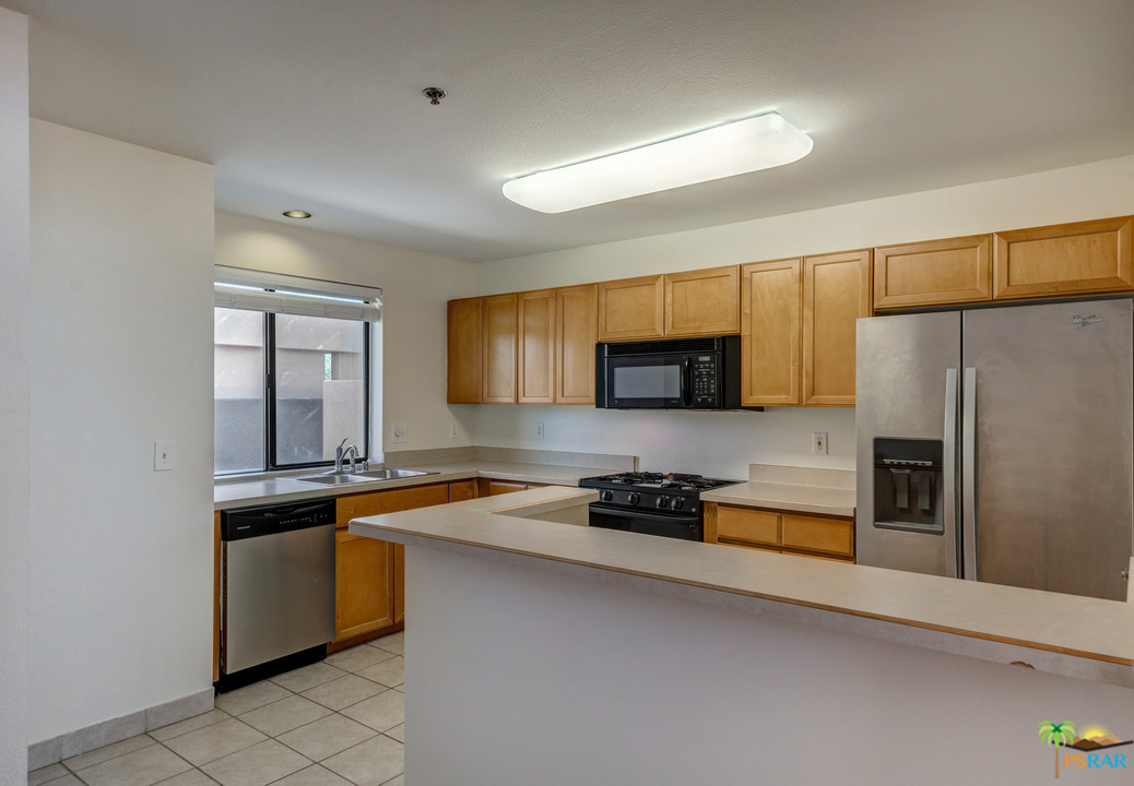 100 East Stevens Road, Unit 509 Palm Springs, CA 92262 - Photo 14 of 37 a kitchen with stainless steel appliances granite countertop a sink a stove a refrigerator a sink a stove and cabinets