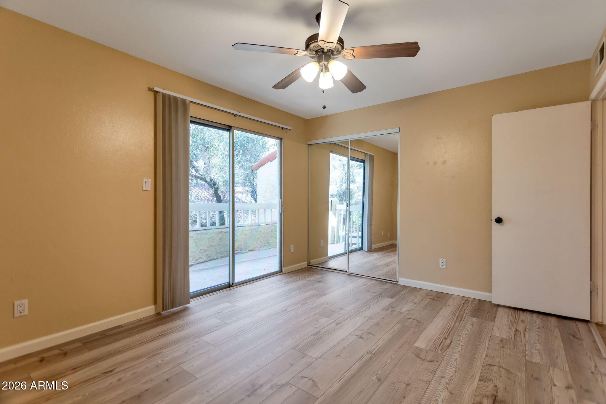 6540 North 7th Avenue, Unit 42 Phoenix, AZ 85013 - Photo 12 of 18 a view of an empty room with window and wooden floor