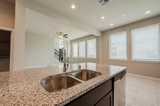 a kitchen with granite countertop a refrigerator and a sink