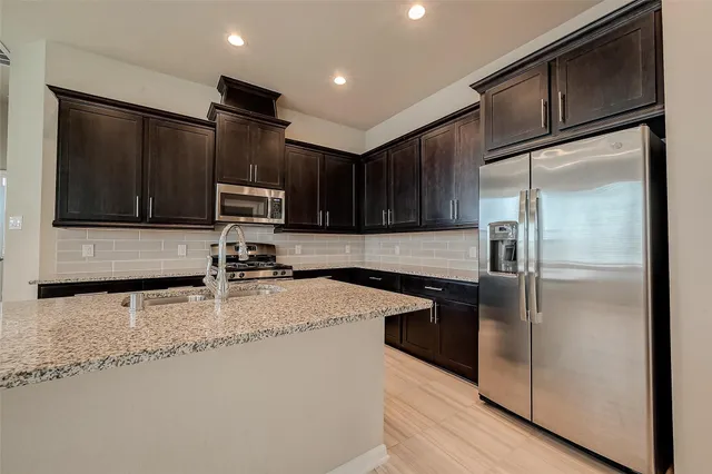 a kitchen with stainless steel appliances granite countertop granite counter tops refrigerator a stove and a sink