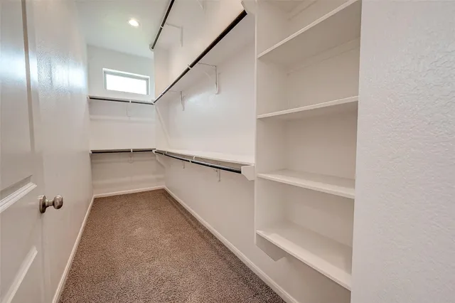 an empty room with a ceiling fan and carpet