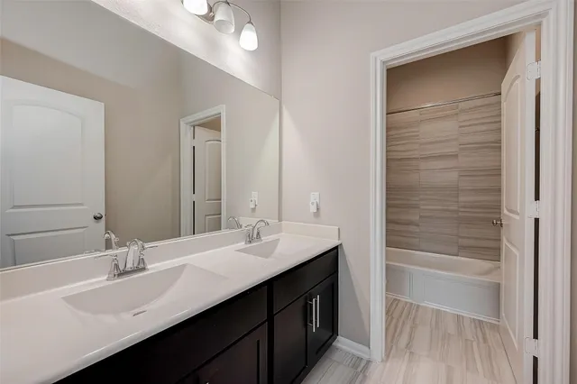 a en suite bathroom with a sink double vanity and mirror
