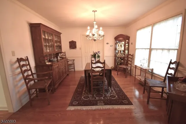 a dining room with furniture a chandelier and wooden floor
