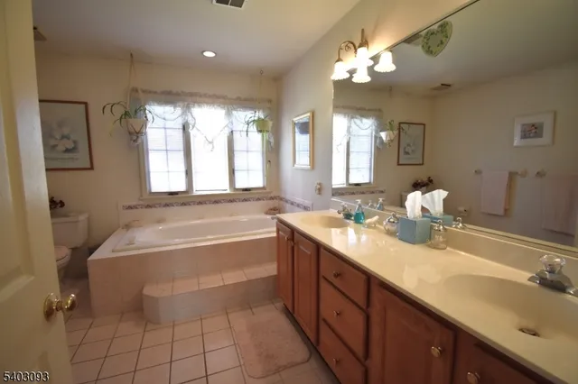 a spacious bathroom with a tub sink and a mirror