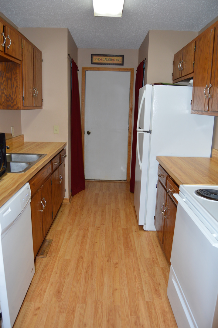 1260 Deerpath Drive Morris, IL 60450 - Photo 7 of 13 a kitchen with a sink a refrigerator freezer a stove top oven a counter space and cabinets