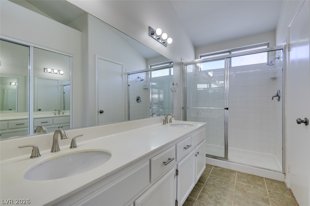 307 Cavalla Street Henderson, NV 89074 - Photo 38 of 44 Bright and airy primary bathroom featuring a dual vanity with ample counter space and a sleek glass-enclosed shower.