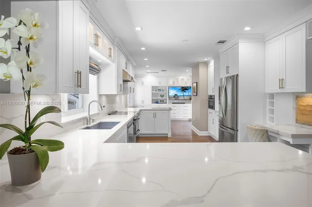 a kitchen with stainless steel appliances a sink a counter top space a large window and stainless steel appliances