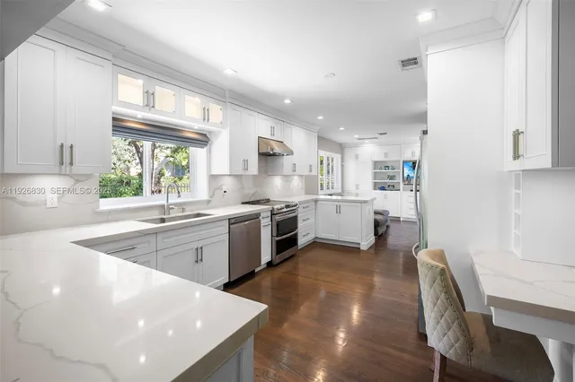 a kitchen with a sink a stove a refrigerator cabinets and a window