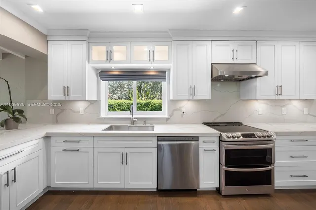 a kitchen with stainless steel appliances a stove a sink and a microwave