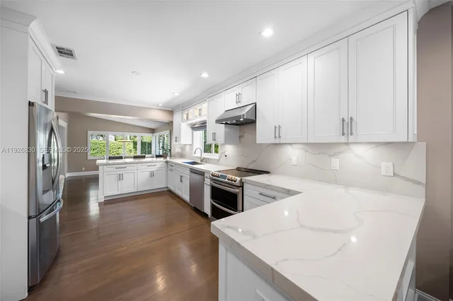 a kitchen with a sink stainless steel appliances and white cabinets