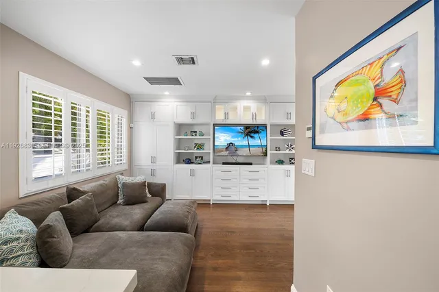 a living room with stainless steel appliances kitchen island furniture and a window