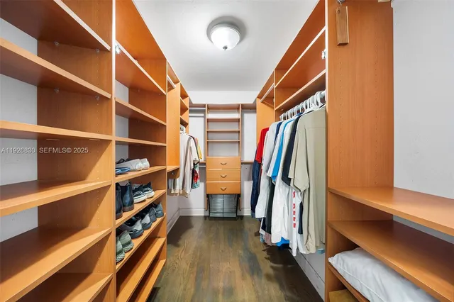 a view of walk in closet with clothes and shoes