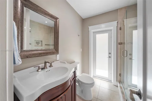 a bathroom with a sink toilet and shower a mirror