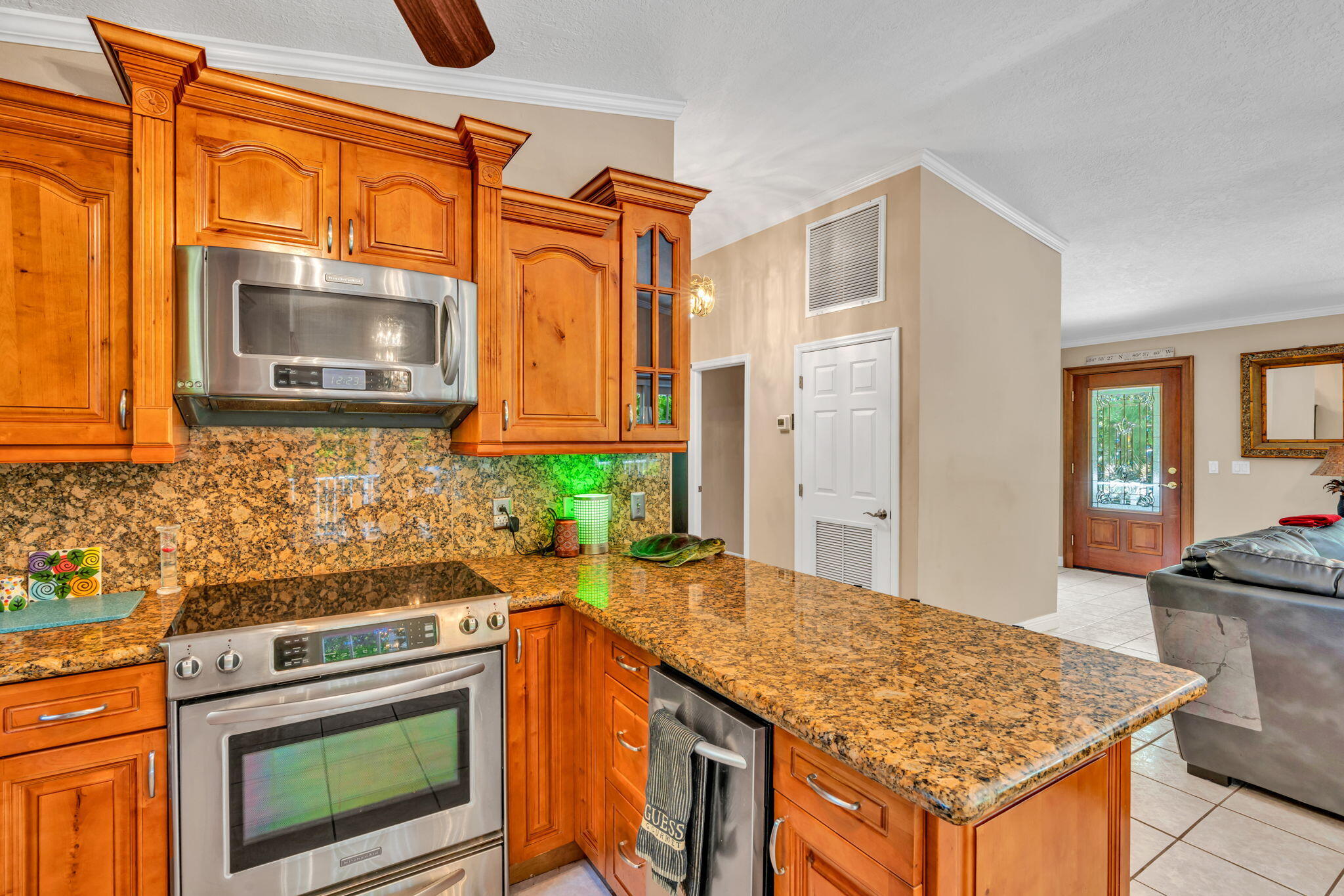125 South Rolling Hill Road Tavernier, FL 33070 - Photo 16 of 48 a kitchen with granite countertop wooden cabinets and a stove top oven