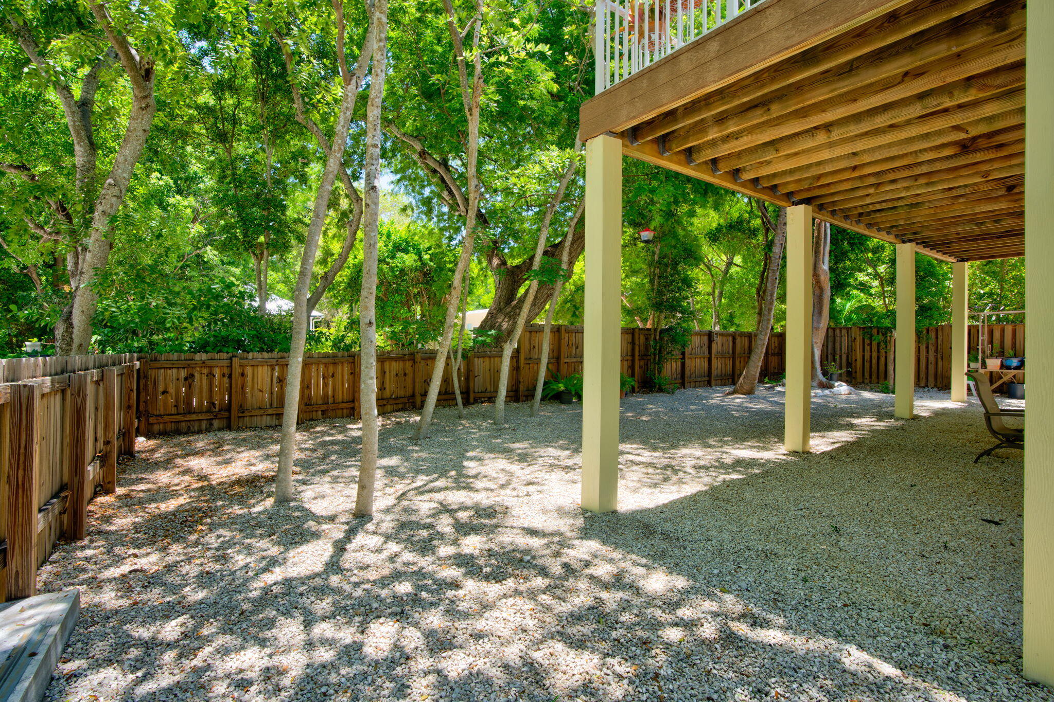 125 South Rolling Hill Road Tavernier, FL 33070 - Photo 31 of 48 a backyard of a house with lots of trees and wooden fence
