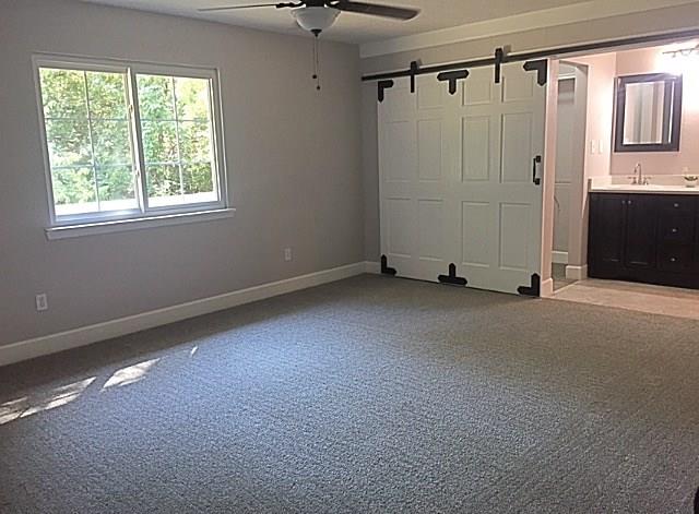 3305 Spaniel Drive Austin, TX 78759 - Photo 6 of 20 A spacious bedroom featuring a classic barn door entrance to the private bathroom.