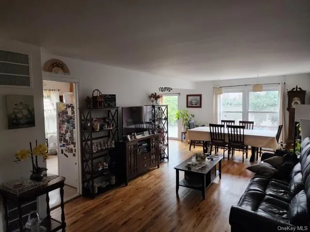 a living room with furniture and a flat screen tv with wooden floor